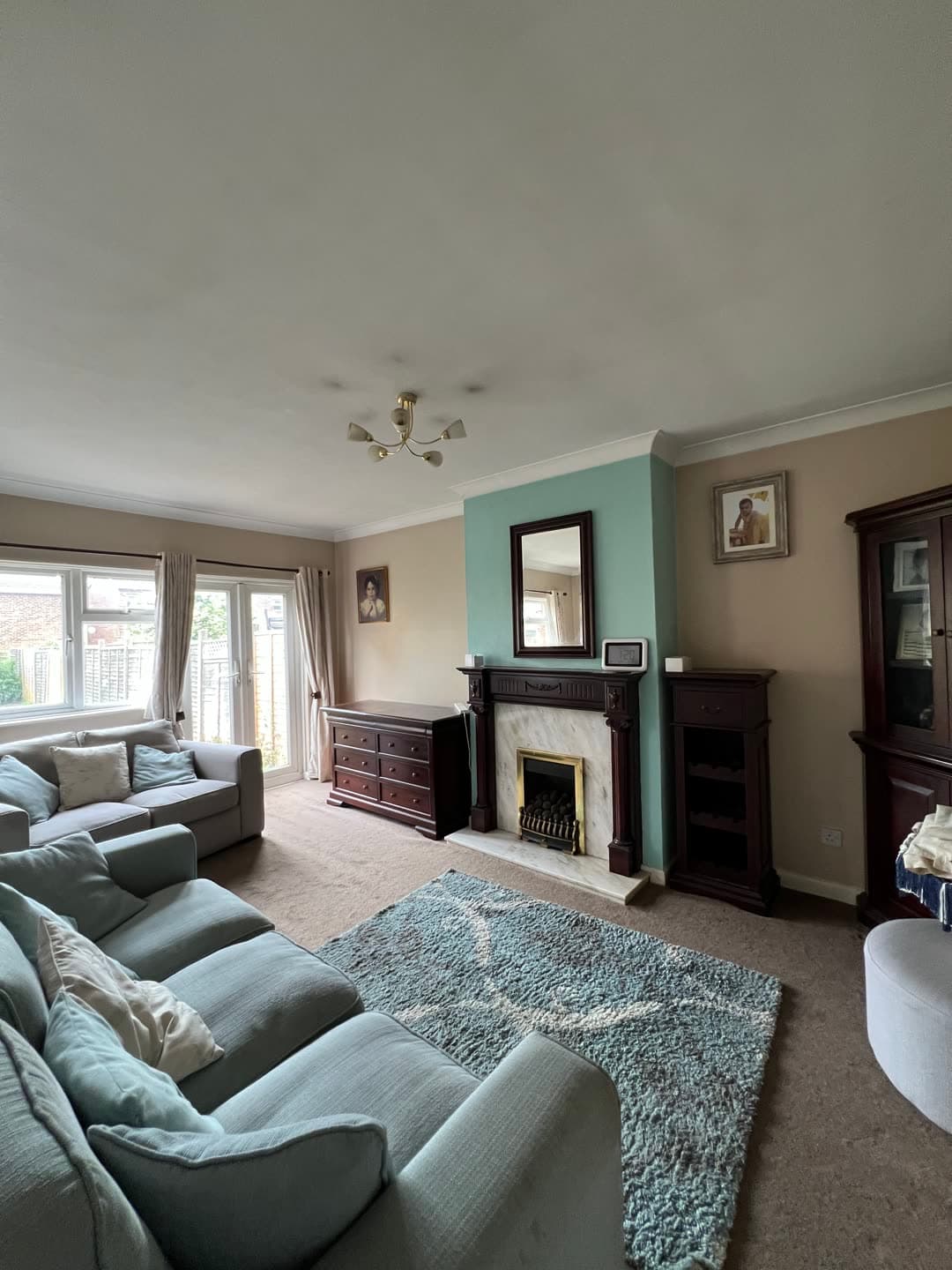 The reception room as found — patterned carpet, dated fireplace surround and inherited furniture
